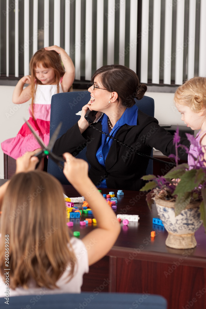 Fototapeta premium Stressed Businesswoman with Children in Office - Working Mom