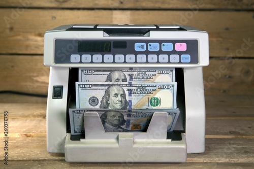 electronic money counter machine is counting is counting the American hundred-dollar (US dollars) banknotes