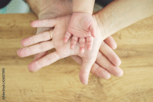 family concept, parents and baby boy hands