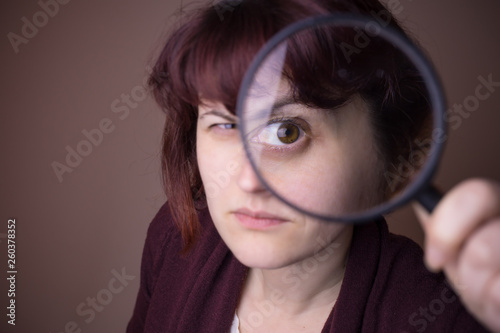 Woman looking through magnifying glass, loop. Investigation, learning concept. Questioning things