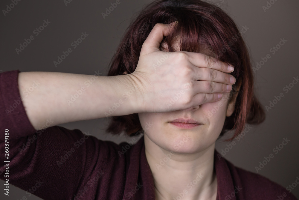 Fototapeta premium Red-haired woman being embarrassed or can't believe something. Hand over eyes. Human facial expression, emotion, feeling, sign symbol body language
