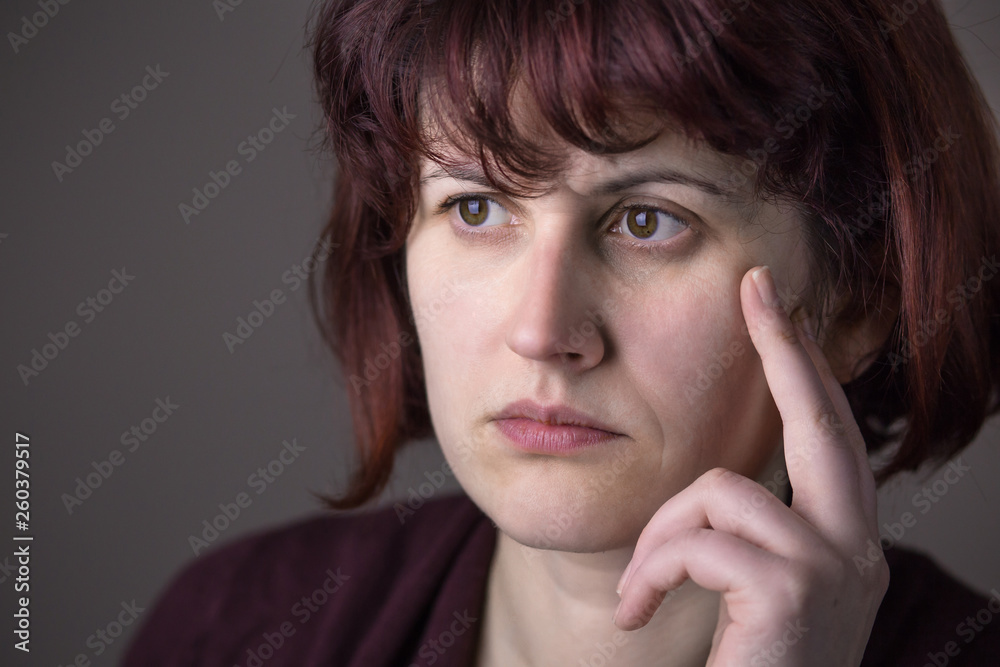 Red-haired woman being worried about something, sad and angry. Human facial expression, emotion, feeling, sign symbol body language Red-haired woman being worried about something, sad and angry. Human facial expression, emotion, feeling, sign symbol body language