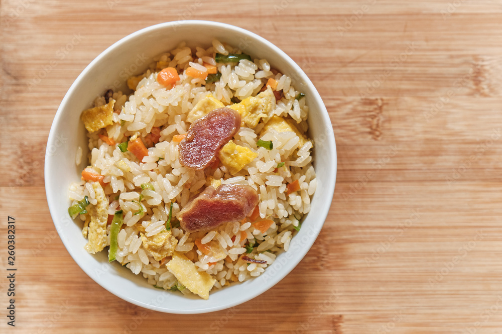 A Bowl of Chinese Fried Rice with Pork Sausages and vegetables. A Bowl of Chinese Fried Rice with Pork Sausages and vegetables.