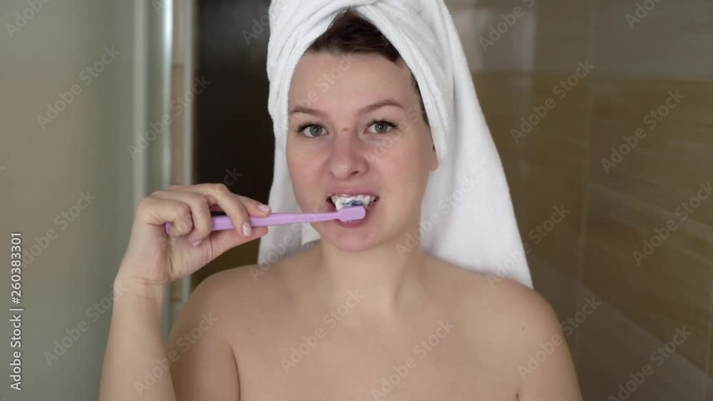 Pretty woman brushing her teeth in modern bathroom Pretty woman brushing her teeth in modern bathroom