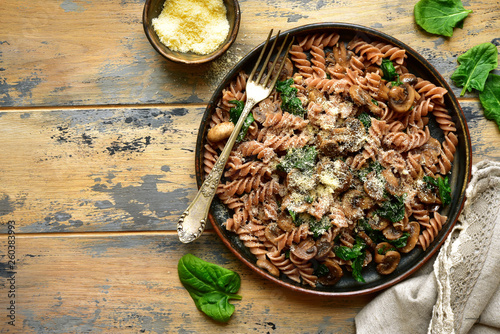 Whole wheat fusilli pasta with mushroom and spinach.Top view with copy space. photo
