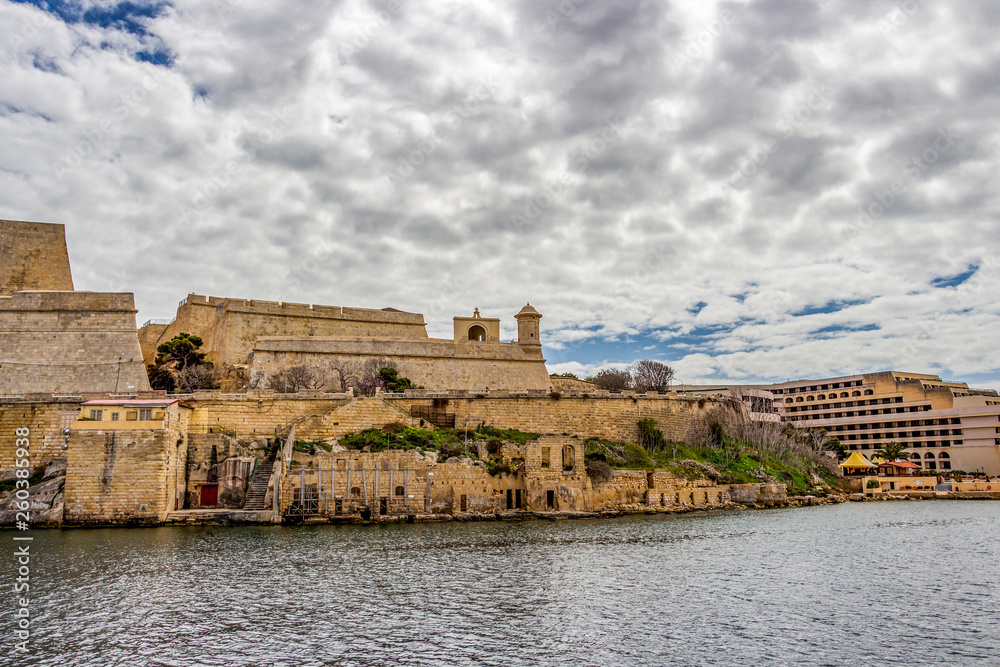 Valletta fortification next to Grand Hotel Excelsior under overcast March sky, at Valletta, Malta