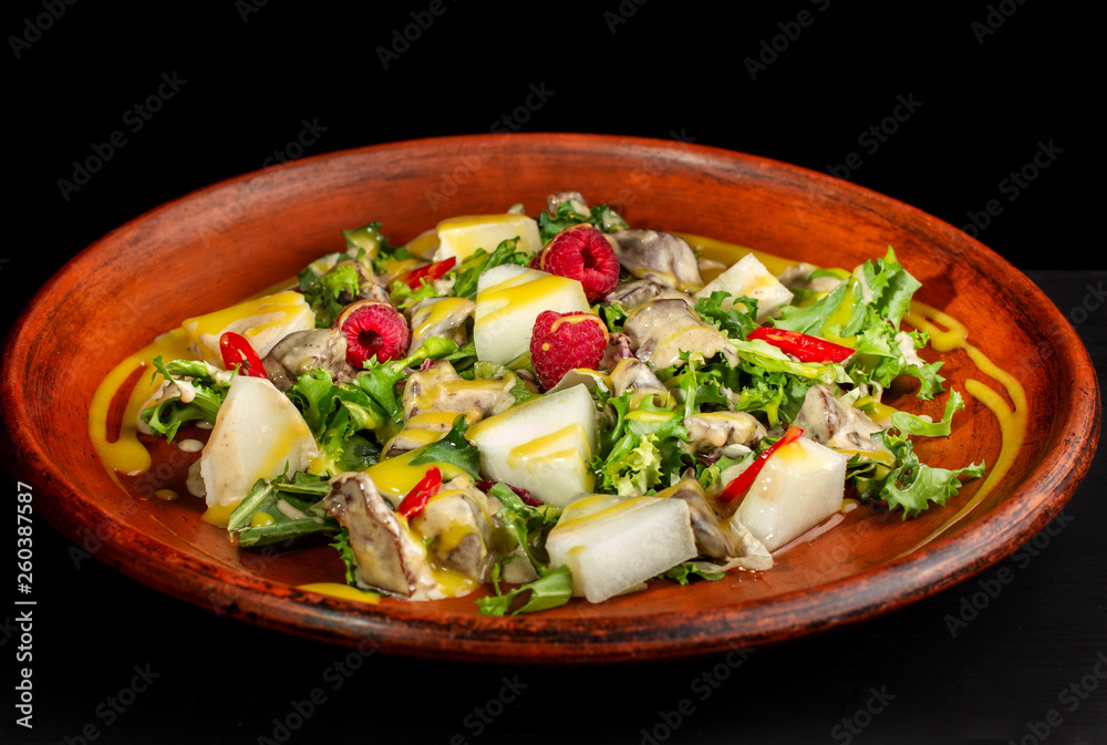 Raspberry, pineapple, lettuce and champignon salad with sauce.