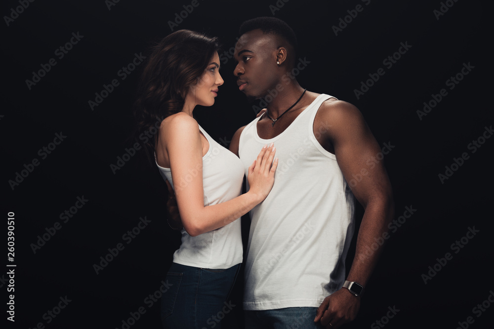 beautiful sensual interracial couple in white tank tops isolated on black beautiful sensual interracial couple in white tank tops isolated on black