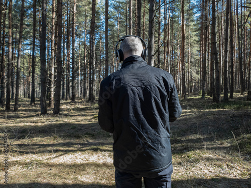 The man in the woods listens to music on headphones