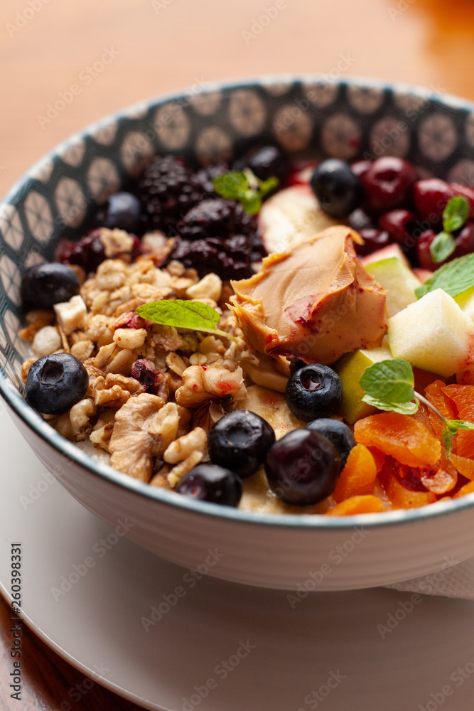Rich oatmeal with fresh berries, nuts, fruit and peanut butter Rich oatmeal with fresh berries, nuts, fruit and peanut butter