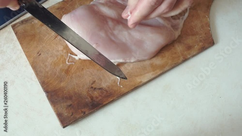 Someone is cutting raw chicken meat beafore frying photo