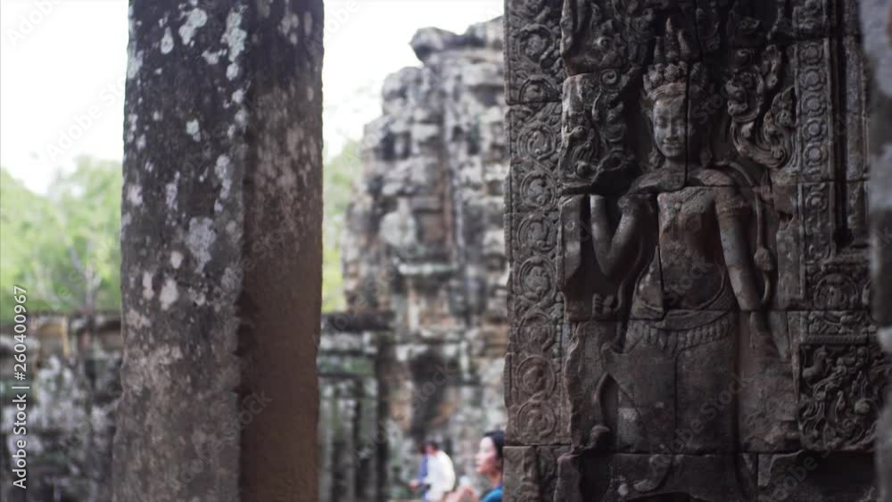 Sliding view of deity carvings on the stone wall at Bayon Temple, a Khmer temple at Angkor in Cambodia built in the late 12th century and richly decorated Sliding view of deity carvings on the stone wall at Bayon Temple, a Khmer temple at Angkor in Cambodia built in the late 12th century and richly decorated