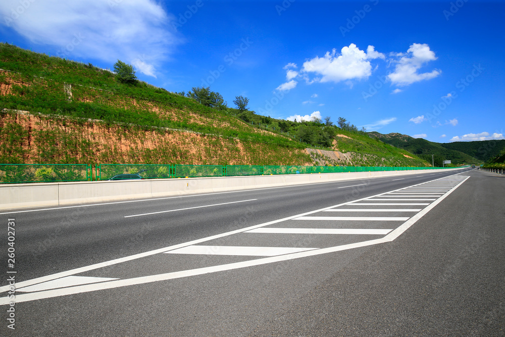 Fototapeta premium Highway, under the background of blue sky and white clouds