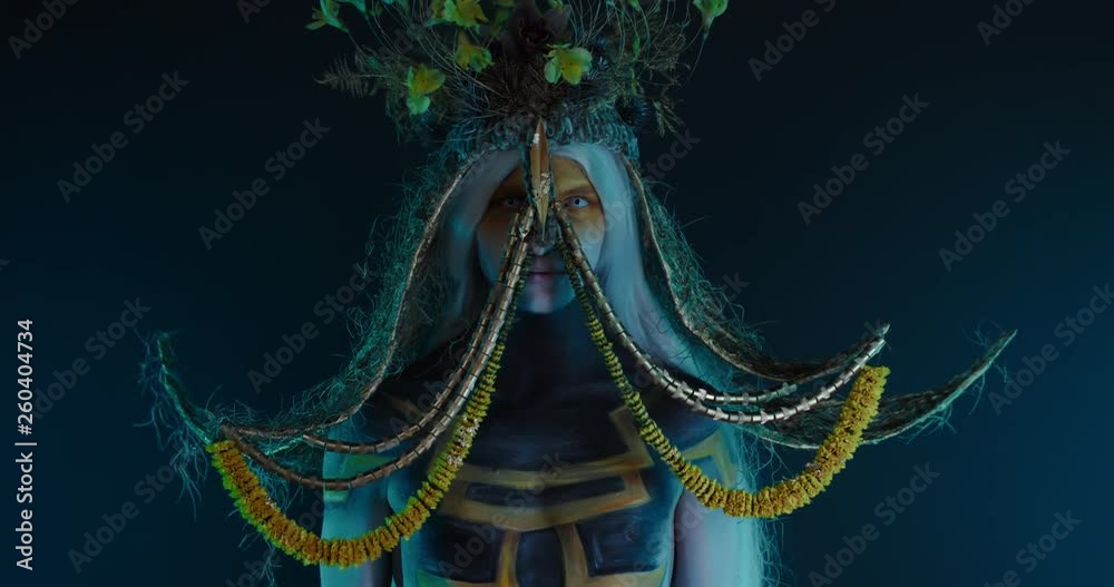 Portrait of Caucasian male with complex warrior floral make-up posing in creative lighting. Body painting fashion project. Model and property released. 4K UHD RAW FOOTAGE