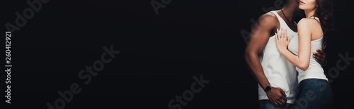 panoramic shot of african american man passionately embracing woman isolated on black with copy space