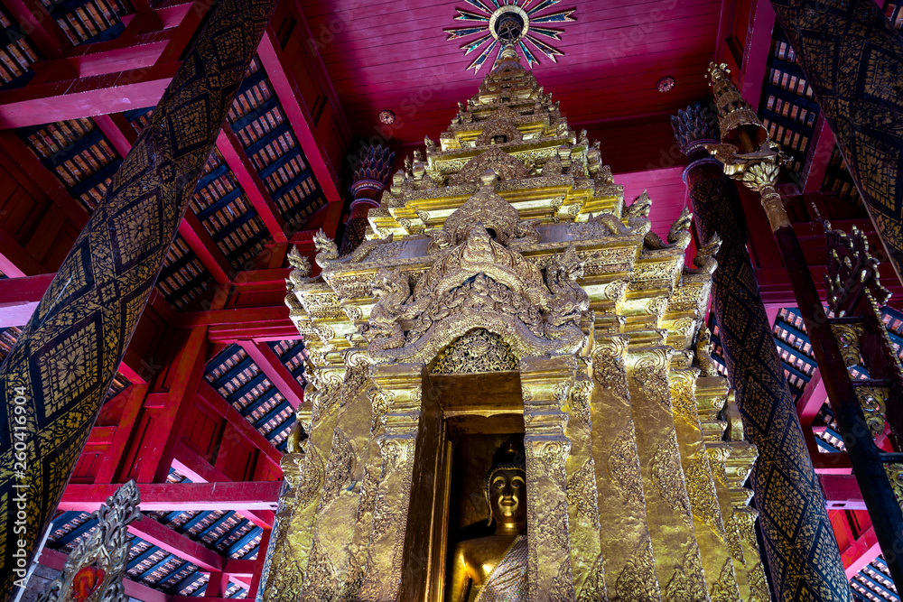 Close-up of Buddha image in golden pagoda at the main hall of Wat Prathat Lampang Luang, an ancient Buddhist temple in Lampang, Thailand. 