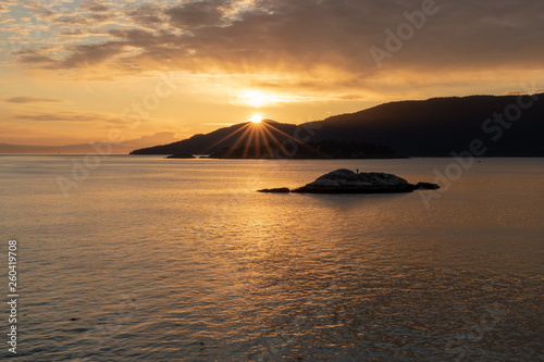 Sun star over the mountains on the coast of Vancouver Canada