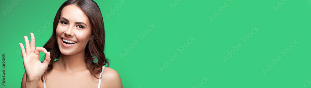 Woman showing okay or zero hand gesture, on blue Woman showing okay or zero hand gesture, on blue