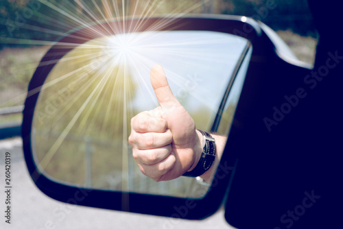 Ein Mann zeigt den Daumen nach oben auf dem Autofenster photo