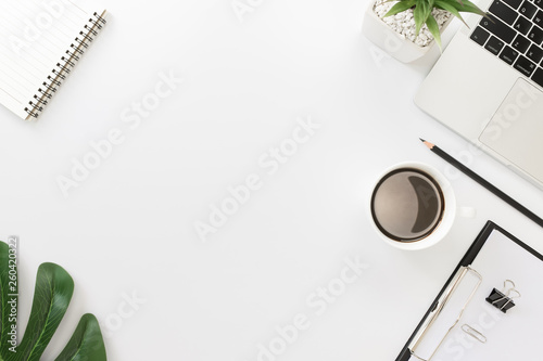 Flay lay, Top view office table desk with smartphone, keyboard, coffee, pencil, leaves with copy space background.