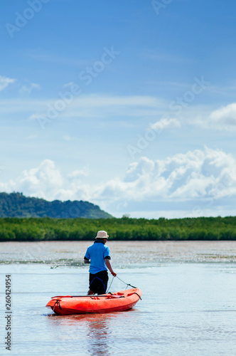 Man draging kayak on mud land of Tung Yee Peng mangrove. Krabi - Thailand