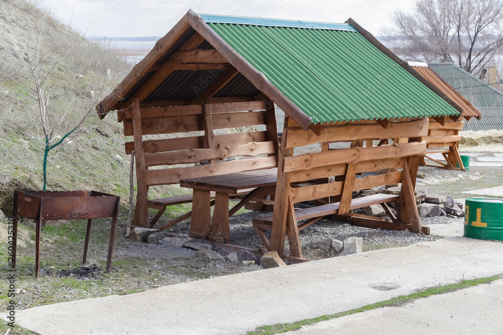 wooden arbor for rest with a roof, a table and benches wooden arbor for rest with a roof, a table and benches