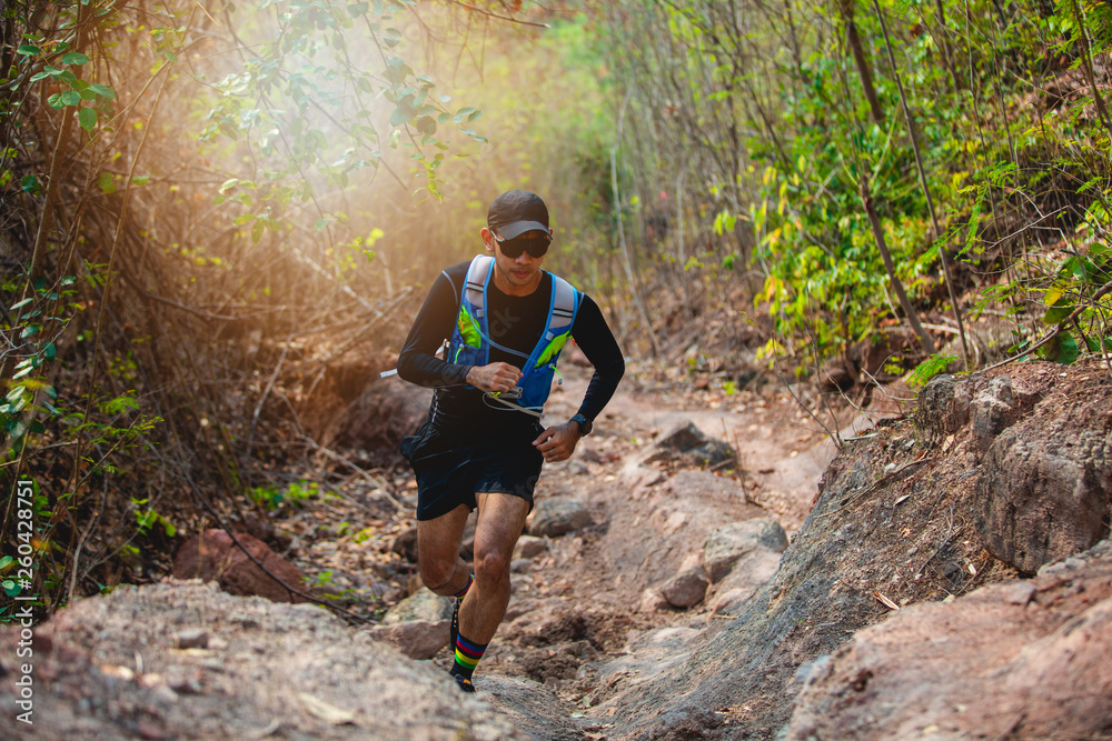 A man Runner of Trail . and athlete's feet wearing sports shoes for trail running in the forest A man Runner of Trail . and athlete's feet wearing sports shoes for trail running in the forest