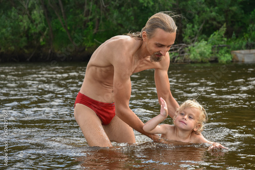 father teaching his little son to swim, they are happy.