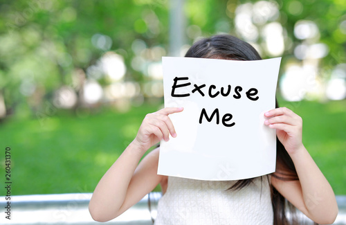 Little child girl holding up a white paper with write text 