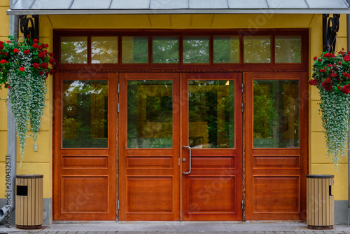 Facade of modern house with wooden door and hanging flowers