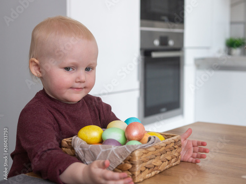 Little child girl with Easter  eggs in basket 