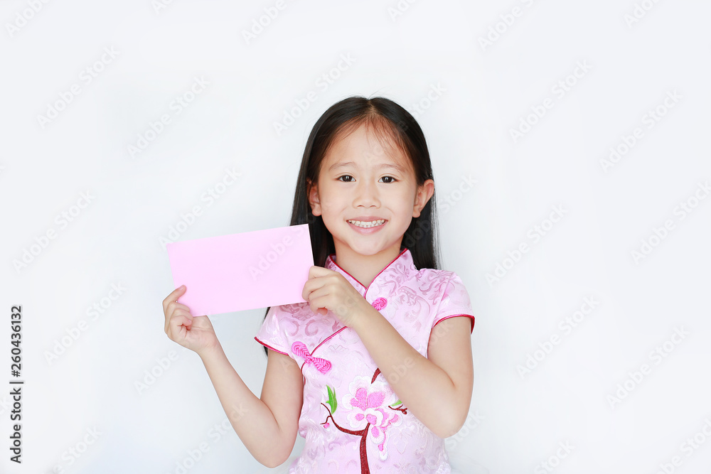 Happy little Asian child girl wearing pink traditional cheongsam dress smiling while receiving Chinese New Year pink envelope packet isolated on white background. Happy chinese new year concept. Happy little Asian child girl wearing pink traditional cheongsam dress smiling while receiving Chinese New Year pink envelope packet isolated on white background. Happy chinese new year concept.
