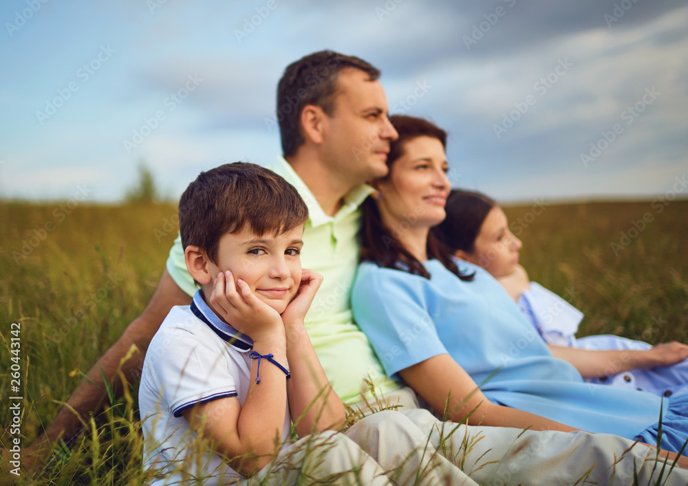 Family resting together sitting on grass in nature. Family resting together sitting on grass in nature.