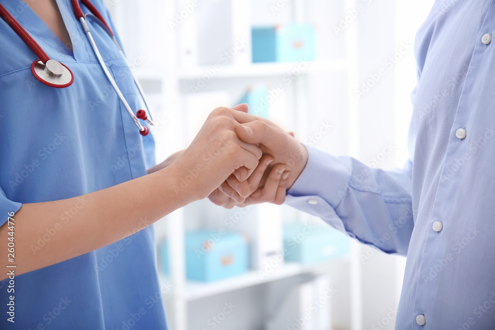 Female doctor comforting her patient in clinic Female doctor comforting her patient in clinic