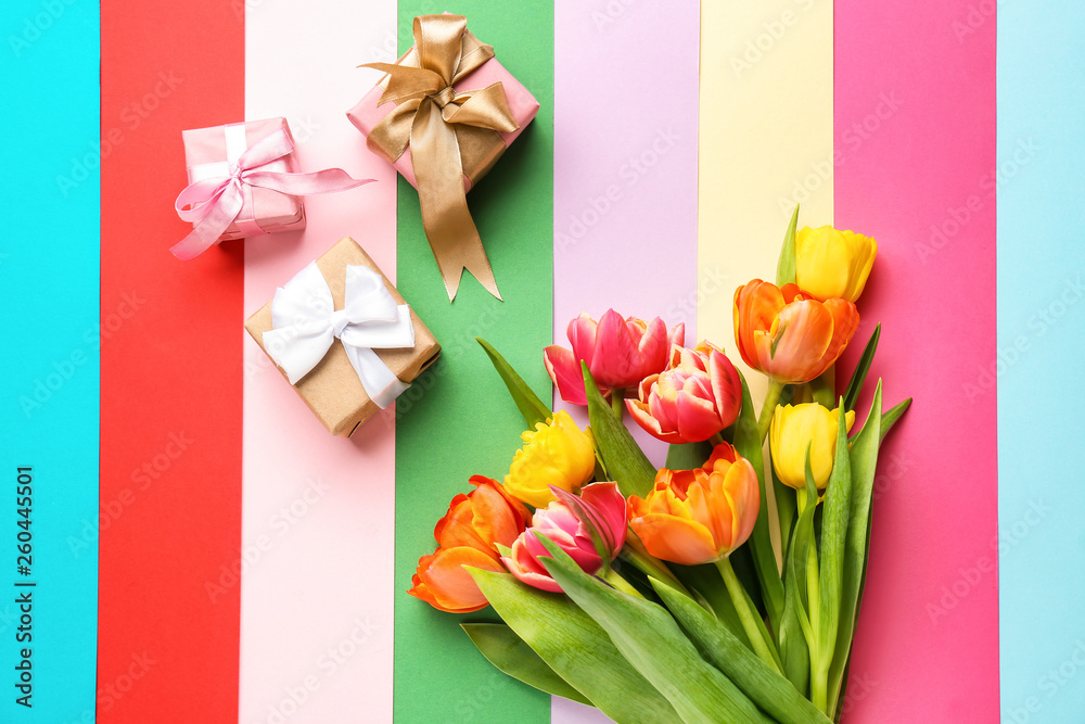 Beautiful tulip flowers with gift boxes on color background