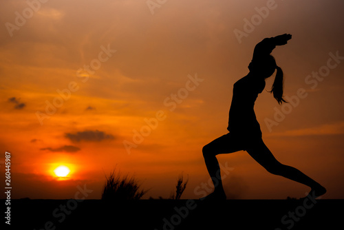 Silhouette Asia woman yoga on sunset. - Image © patcharee11