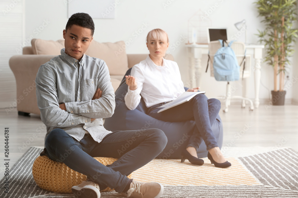 Fototapeta premium Female psychologist working with teenage boy in office