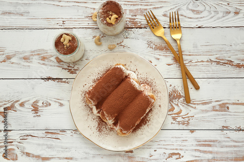 Tasty tiramisu on white wooden table