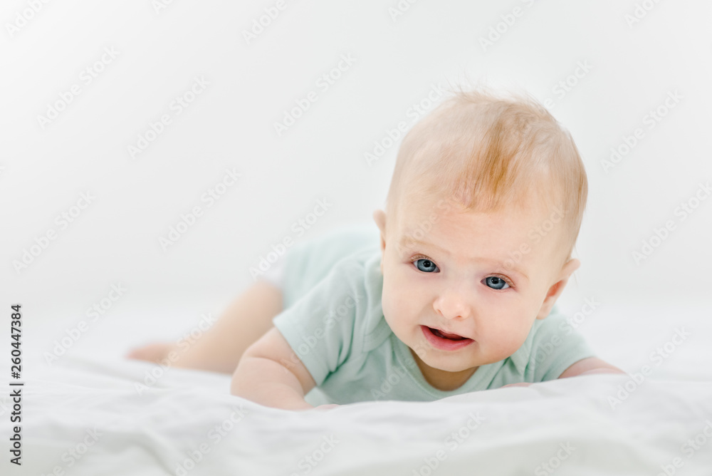 Portrait of cute newborn baby lying on belly at home