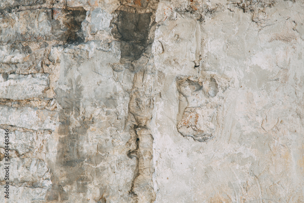 Textured wall of the old house. The texture of old cracked concrete with paint.