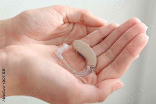 Female hands with hearing aid  closeup