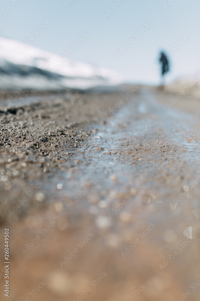Blurred background and bokeh. The texture of the mud on the ground with a glare. Blurred background and bokeh. The texture of the mud on the ground with a glare.