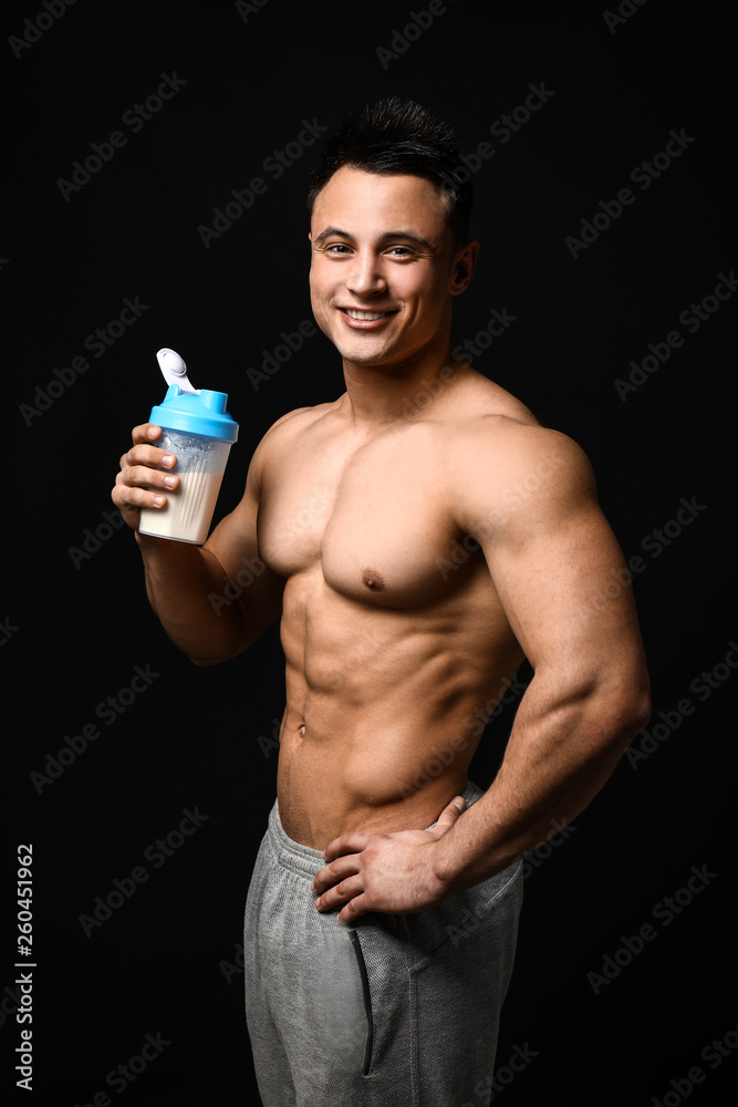 Sporty man with protein shake on dark background Sporty man with protein shake on dark background