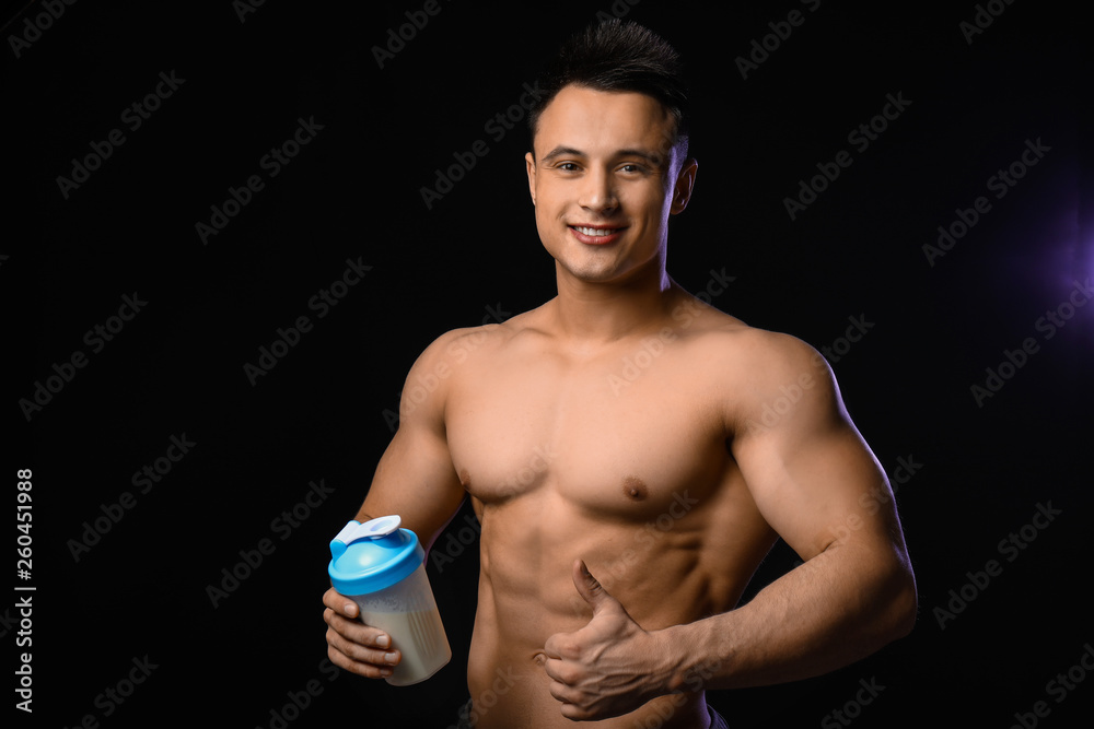 Sporty man with protein shake on dark background Sporty man with protein shake on dark background