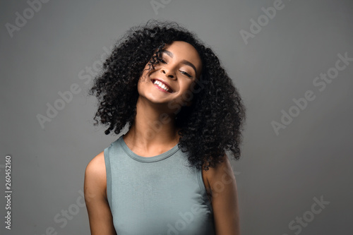 Beautiful African-American woman on grey background