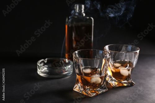 Glasses of cold whiskey on dark background