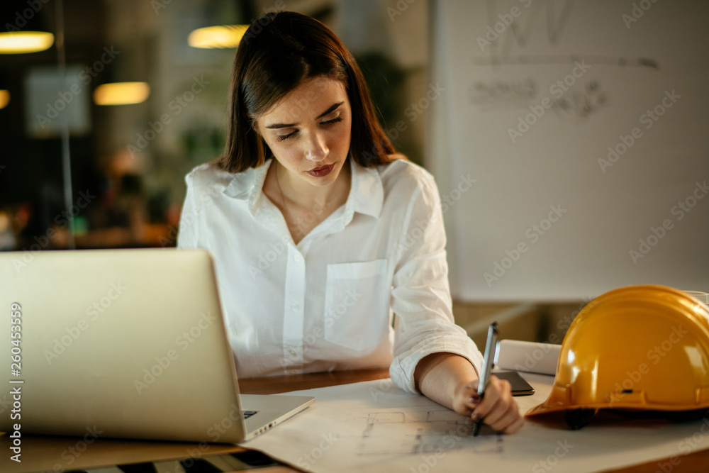 Young woman architect working on a project. Female engineer at her desk. Young woman architect working on a project. Female engineer at her desk.