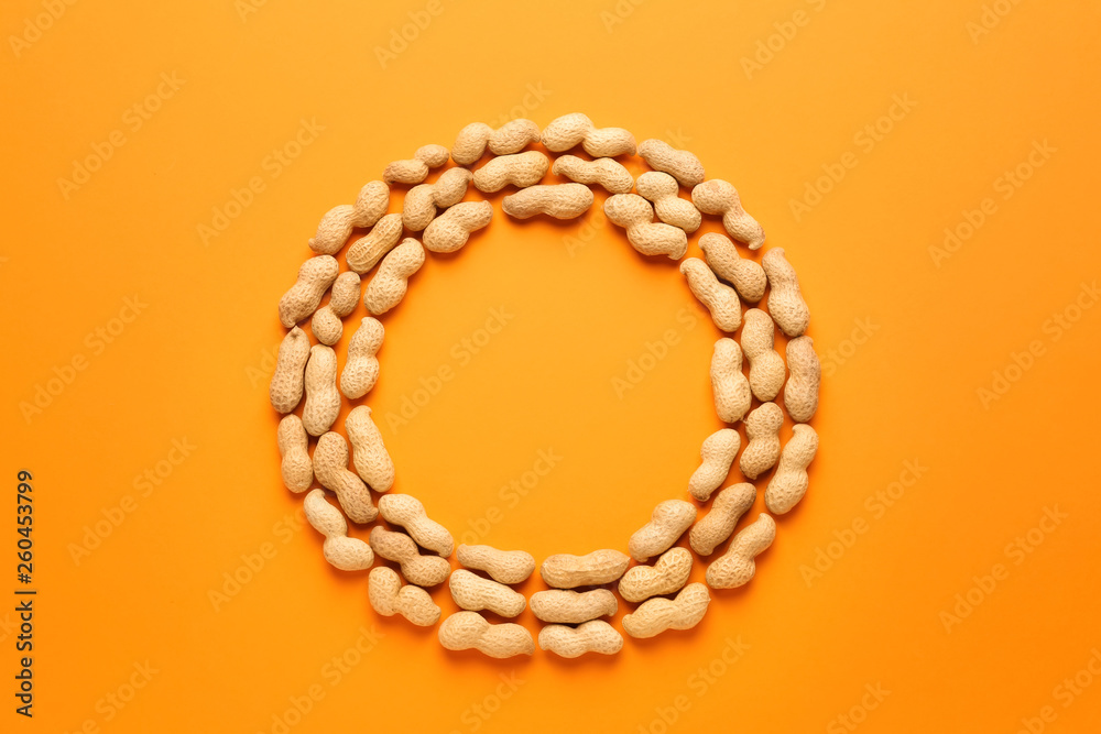 Obraz premium Frame made of tasty peanuts on color background