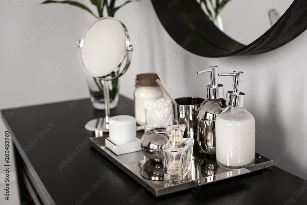Tray with cosmetic products on dark table in room Tray with cosmetic products on dark table in room
