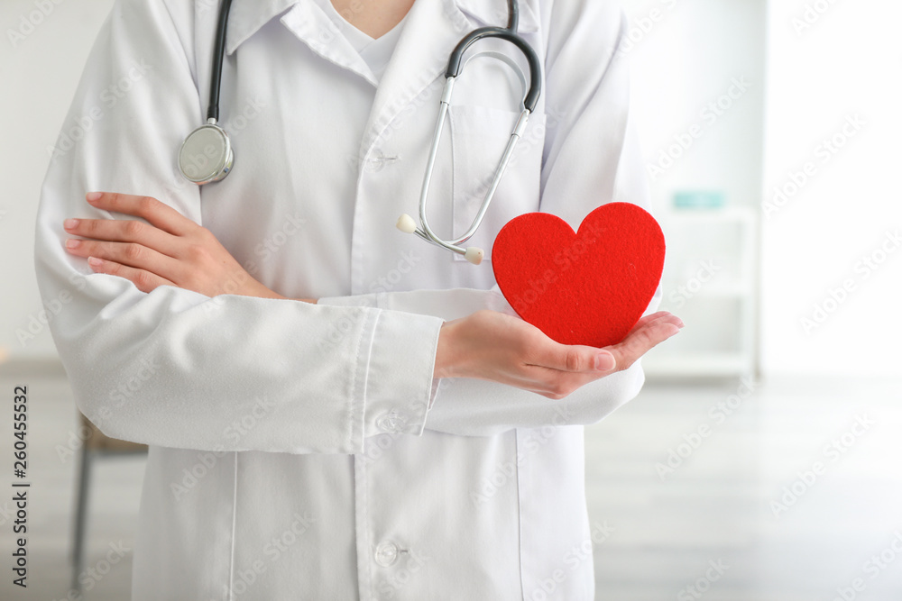 Cardiologist with red heart in clinic Cardiologist with red heart in clinic